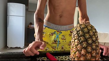 Skinny guy with a big dick sucking on a pineapple and showing off his nice cock.
