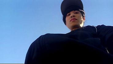 Freeballing in public, this twink walks outdoors commando, no underwear beneath his black Adidas tracksuit, Campus sneakers, while out cruising