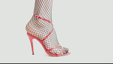 Feet In Black Fishnet Pantyhose Tights And Red High Heels
